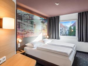a hotel room with two beds and a window at B&B Hotel Hamburg-Airport in Hamburg