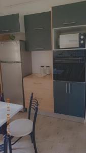 Appartement meublé في قسنطينة: مطبخ مع موقد وطاولة وميكروويف