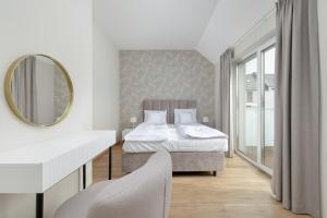 1 dormitorio con 2 camas y espejo en Sunny Hills Villas - Kołobrzeg by Jantar Apartamenty, en Kołobrzeg