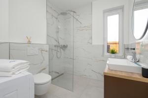 Baño blanco con aseo y lavamanos en Sunny Hills Villas - Kołobrzeg by Jantar Apartamenty en Kołobrzeg