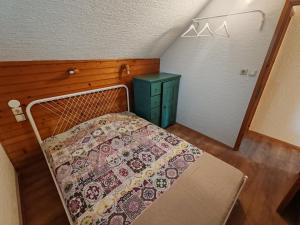 a bedroom with a bed and a green cabinet at Apartment Ursa Major & Glamp Barba in Preddvor