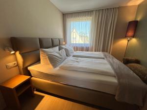 a bed in a small room with a window at Maxhotel in Lindau +50 photos