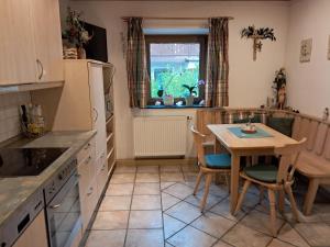 eine Küche mit einem Tisch, einem Tisch und Stühlen in der Unterkunft Hotel Garni Edelweiß in Siegsdorf