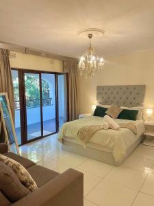a bedroom with a large bed and a chandelier at The Garden of Eden in Johannesburg