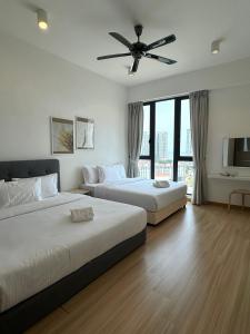 two beds in a bedroom with a ceiling fan at Jazz Suites Seaview with Bathtub - 1603 in Tanjong Tokong