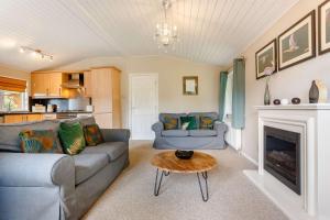 a living room with a couch and a fireplace at Kingham Lodge in Kingham