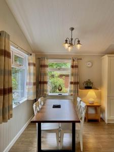 a dining room with a table and chairs and a window at Norton Plus Lodge 29 in Kingham +2 photos
