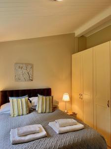 a bedroom with a bed with two towels on it at Norton Plus Lodge 29 in Kingham