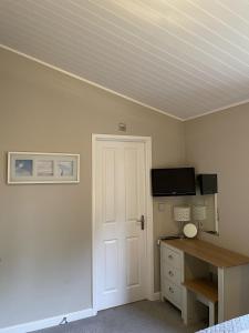 a room with a bed and a desk and a door at Norton Plus Lodge 29 in Kingham