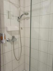 a bathroom with a shower with a glass door at CityPark Aparthotel in Cologne