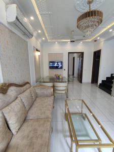 a living room with a couch and a glass table at Luxury New Designer 3 BDRM Entire Home DHA Lahore Near Airport in Lahore