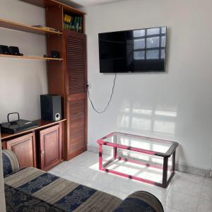 a room with a glass table and a tv on the wall at Casa Familiar- Turística Manríque Medellín in Medellín