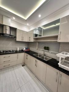 a kitchen with white cabinets and a sink at Luxury New Designer 3 BDRM Entire Home DHA Lahore Near Airport in Lahore