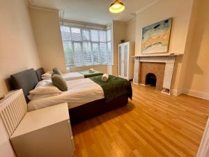 um quarto com uma cama grande e uma lareira em Clare House - sleeps 14 em Bedford