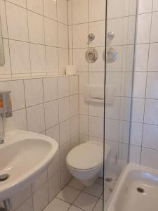 uma casa de banho branca com um WC e um lavatório em CityPark Aparthotel em Colônia