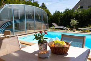 uma mesa com uma cesta de frutas sobre uma mesa ao lado de uma piscina em Balaton Fantasy Villa em Balatonfüred