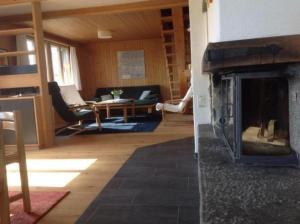 uma sala de estar com lareira numa casa em Ferienhaus "Datscha" freistehend, Garten, Labelfamily destination em Lenk