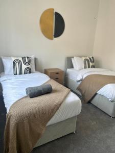 een slaapkamer met 2 bedden en een spiegel aan de muur bij Free Parking! Comfy home in Barwell, Leicester -b- 