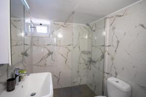 a bathroom with a toilet and a sink and a shower at Two Bedroom Apartment, Mytilene Lesvos in Mytilini