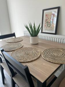 een houten tafel met vier ronde platen erop bij Free Parking! Comfy home in Barwell, Leicester -b- 