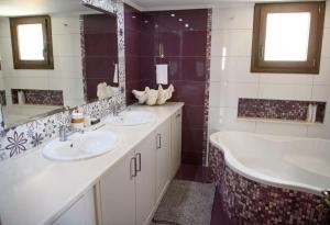 a bathroom with two sinks and two mirrors and a tub at Βίλα Μαρία Νεφέλη για μαγικές διακοπές στο νησί μας in Panormos Kalymnos +40 photos