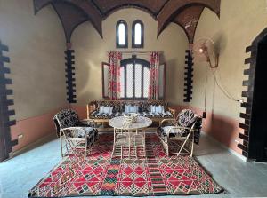 un comedor con mesa y sillas en una habitación en The Desert House, Luxor, Westbank, en ‘Ezbet Abu Ḥabashi
