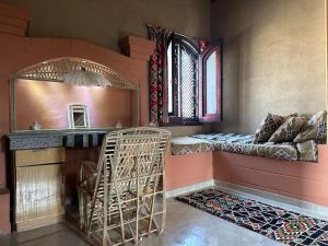 een kamer met een bed, een spiegel en een stoel bij The Desert House, Luxor, Westbank in ‘Ezbet Abu Ḥabashi