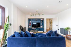 un sofá azul en la sala de estar con TV en City View Spacious 2 bedroom Penthouse en Londres