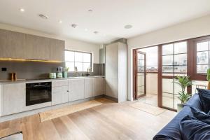 a living room with a couch and a kitchen at City View Spacious 2 bedroom Penthouse in London