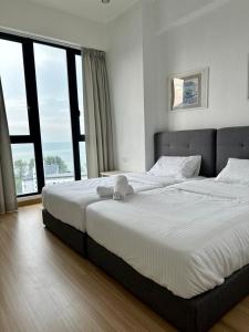 a bedroom with a large bed with a large window at Jazz Suites Seaview with Bathtub - 1603 in Tanjong Tokong