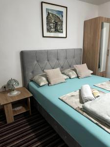 um quarto com uma cama azul e uma mesa em Guest House Nana em Mostar