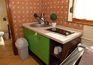 a kitchen with a sink and a green cabinet at Makotel Apartmanház in Makó