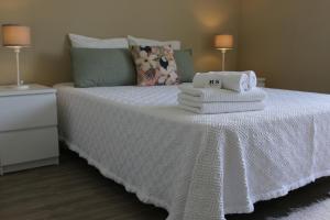 ein Schlafzimmer mit einem Bett mit Handtüchern darauf in der Unterkunft RS Apartamento in Quarteira
