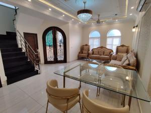 a living room with a glass table and chairs at Luxury New Designer 3 BDRM Entire Home DHA Lahore Near Airport in Lahore
