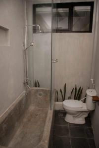 a bathroom with a shower and a toilet and a tub at Sora Boutique Stay in Ciwidey +20 photos