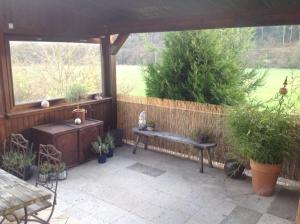 a patio with potted plants and a wooden pergola at Große, hundefreundliche Ferienwohnung mit großer Terrasse in Flussnähe in Medebach