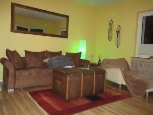 a living room with a brown couch and a mirror at Große, hundefreundliche Ferienwohnung mit großer Terrasse in Flussnähe in Medebach +14 photos