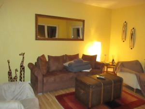 a living room with a brown couch and a mirror at Große, hundefreundliche Ferienwohnung mit großer Terrasse in Flussnähe in Medebach