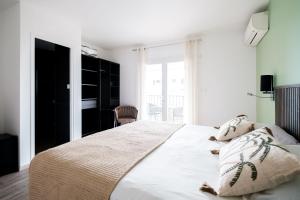 a bedroom with a large white bed with two pillows at Anglade Hotel in Le Lavandou