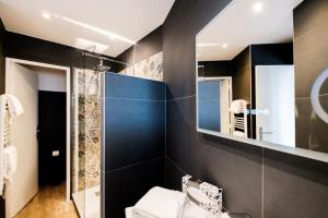 a bathroom with a toilet and a mirror at Anglade Hotel in Le Lavandou
