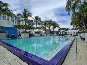 una gran piscina con palmeras en un complejo en WVR Vacation Residences 709 en Fort Lauderdale