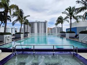 a large swimming pool on the roof of a building with palm trees at WVR Vacation Residences 709 in Fort Lauderdale