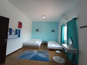 una camera con due letti, un tavolo e uno specchio di DONG’HOME东东小院 a Semporna