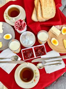 a table topped with plates and cups of coffee and bread at Nika's Guest House in Berat
