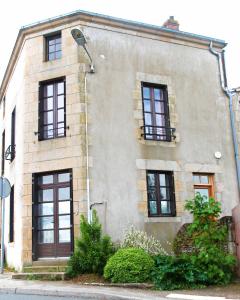 a stone house with black windows at Gîte Le Féodal 3 Etoiles in Tiffauges