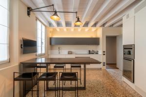 Palazzo Morosini Degli Spezieri - Apartments في البندقية: مطبخ مع طاولة وكراسي في غرفة