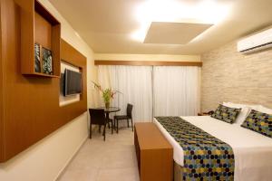 ein Hotelzimmer mit einem Bett und einem Tisch in der Unterkunft Pousada Tabapitanga in Porto De Galinhas