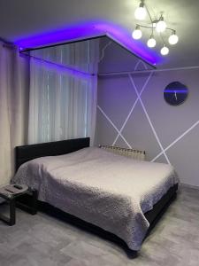 sypialnia z łóżkiem z fioletowym oświetleniem w obiekcie Love Room & Spa Jacuzzi w mieście Fleury-les-Aubrais