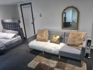 a living room with a couch with pillows and a mirror at Affordable Private Space in a Central Part of Leeds- Free WIFI, Free Parking in Leeds