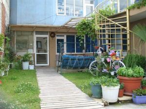 a house with a bunch of plants in the yard at Къща за гости Стил in Kiten